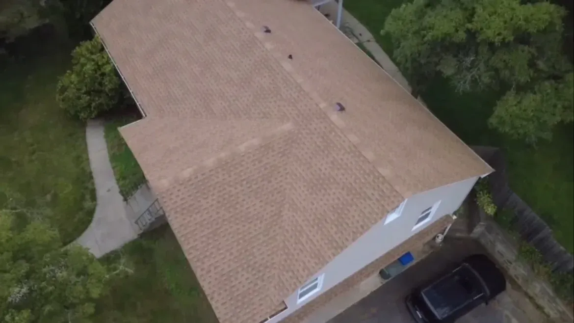 Aerial view of asphalt shingle roof installation on a residential home